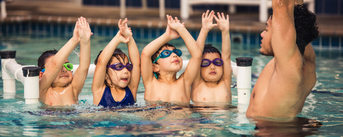 A swimming trainer showing children techniques for swimming in San Francisco, CA