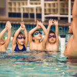 A swimming trainer showing children techniques for swimming in San Francisco, CA