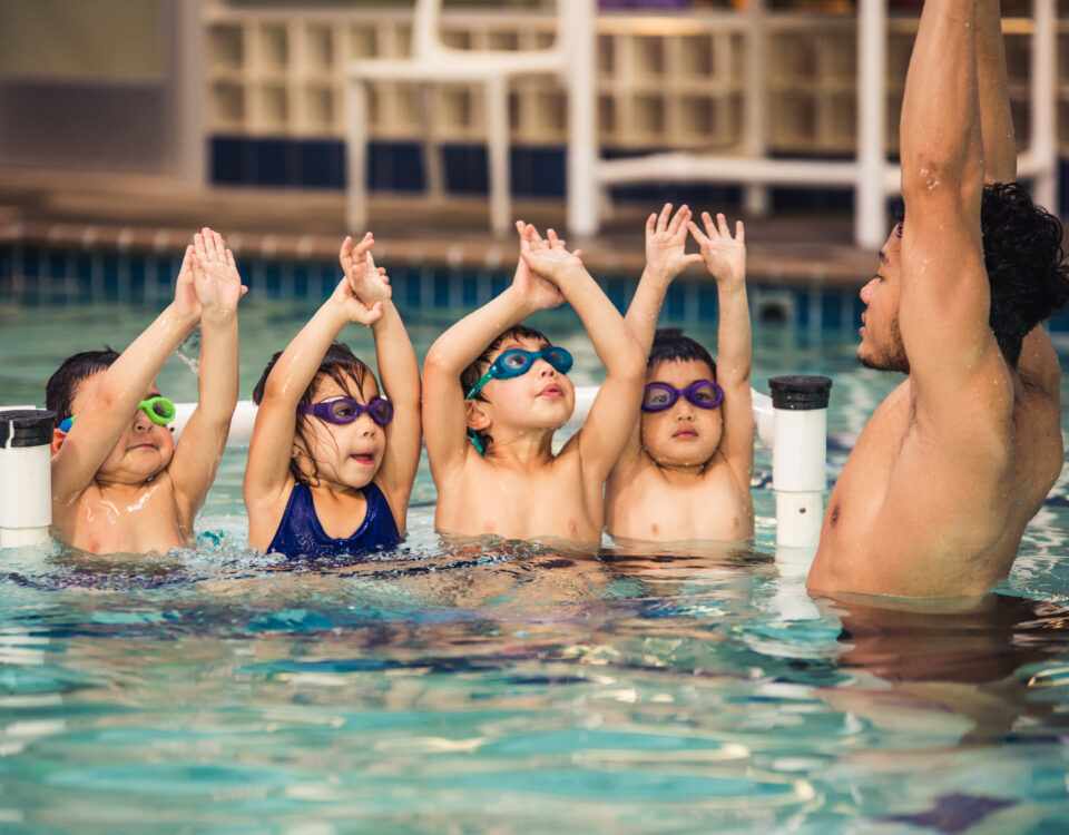 A swimming trainer showing children techniques for swimming in San Francisco, CA