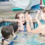 A trainer coaches children for swimming in San Francisco, CA