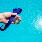 A Swimmer Holding a Medal After Winning a Swimming Competition in CA