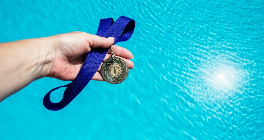 A Swimmer Holding a Medal After Winning a Swimming Competition in CA