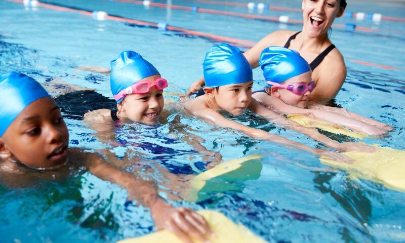 Children in group swimming lessons in San Francisco, CA, are building skills & teamwork in the pool.